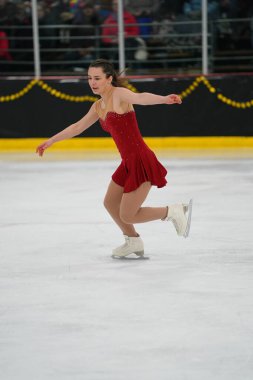 Mosinee, Wisconsin ABD - 26 Şubat 2021: Porsuk Eyaleti buz pateni yarışmasına katılan kırmızı elbiseli genç bir kadın.