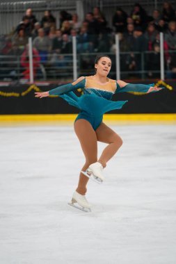 Mosinee, Wisconsin ABD - 26 Şubat 2021: Porsuk eyaleti buz pateni yarışmasına katılan turkuaz elbiseli yetişkin kadın