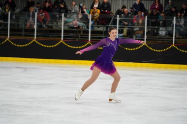 Mosinee, Wisconsin ABD - 26 Şubat 2021: Porsuk eyaleti buz pateni yarışmasına katılan güzel mor elbiseli beyaz kadın