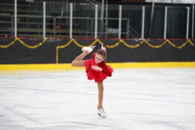 Mosinee, Wisconsin ABD - 26 Şubat 2021: Porsuk Eyaleti buz pateni yarışmasına güzel kırmızı elbiseli yetişkin kadın katıldı