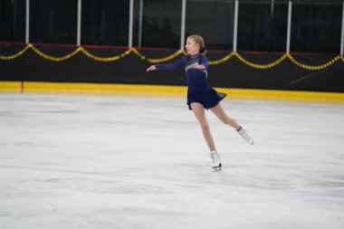 Mosinee, Wisconsin ABD - 26 Şubat 2021: Porsuk eyaleti buz pateni yarışmasına katılan güzel renkli elbiseli genç bir kadın