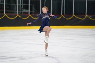 Mosinee, Wisconsin ABD - 26 Şubat 2021: Porsuk eyaleti buz pateni yarışmasına katılan güzel renkli elbiseli genç bir kadın