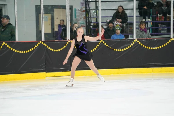 米国ウィスコンシン州モシニア 2021年2月26日 美しい黒いドレスの若いティーンエイジャーの女性が より悪い州の冬のゲームアイススケート競技に参加しました — ストック写真