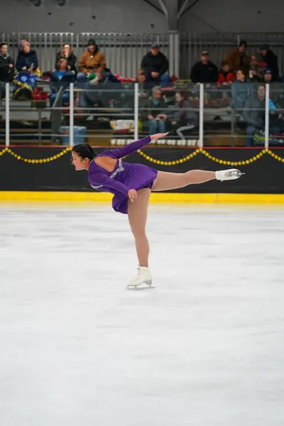 米国ウィスコンシン州モシニア 2021年2月26日 美しい紫色のドレスのアジアの成人女性がより悪い州の冬のゲームアイススケート競技に参加しました — ストック写真