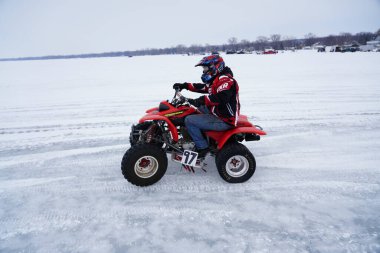 Fond du Lac, Wisconsin / USA - 9 Mart 2019: İnsanlar donmuş karavan gölünde ATV ve Quad motosikletleriyle buzun üzerinde gezerken eğleniyorlar