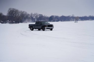 Fond du Lac, Wisconsin / USA - 9 Mart 2019: İnsanlar donmuş karavan gölünde buzun üzerinde araçları sürerken eğleniyorlar