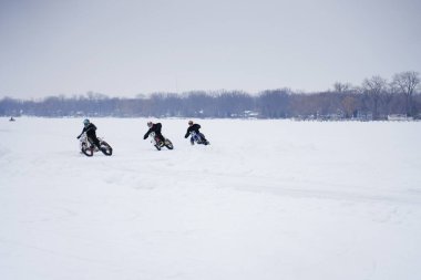 Hortonville, Wisconsin / ABD - 26 Ocak 2019: Toprak motosikletli sürücüler donmuş buzlu göl üzerinde gezinirken eğleniyorlardı