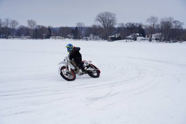 Hortonville, Wisconsin / ABD - 26 Ocak 2019: Toprak motosikletli sürücüler donmuş buzlu göl üzerinde gezinirken eğleniyorlardı
