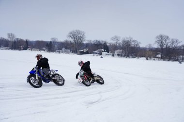 Hortonville, Wisconsin / ABD - 26 Ocak 2019: Toprak motosikletli sürücüler donmuş buzlu göl üzerinde gezinirken eğleniyorlardı