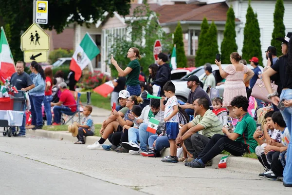 Milwaukee, Wisconsin ABD - 16 Eylül 2023: Latin Amerikalı aileler Meksika Bağımsızlık Günü Geçidi 'ni izlemek ve izlemek için cadde boyunca toplandı.