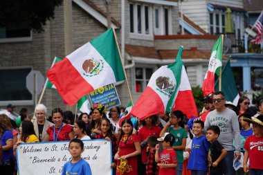 Milwaukee, Wisconsin ABD - 16 Eylül 2023: Latin Amerikalı aileler Meksika Bağımsızlık Günü Geçidi 'ni izlemek ve izlemek için cadde boyunca toplandı.