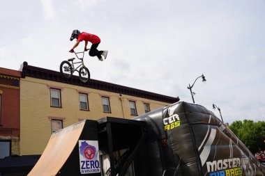 Racine, Wisconsin ABD - 16 Eylül 2023: BMX bisikletli dublörler, Racine, Wisconsin sokaklarında bir grup insan için yarı boru rampalarında dublörlük yapıyor.