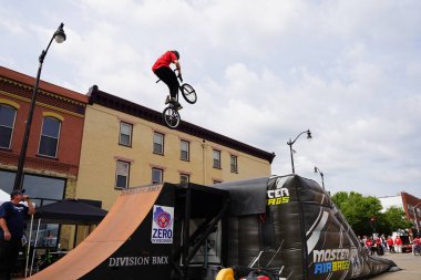 Racine, Wisconsin ABD - 16 Eylül 2023: BMX bisikletli dublörler, Racine, Wisconsin sokaklarında bir grup insan için yarı boru rampalarında dublörlük yapıyor.
