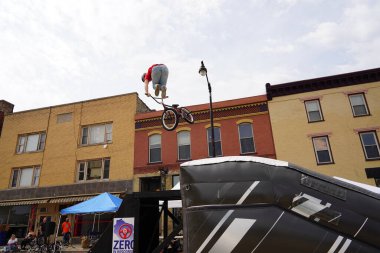 Racine, Wisconsin ABD - 16 Eylül 2023: BMX bisikletli dublörler, Racine, Wisconsin sokaklarında bir grup insan için yarı boru rampalarında dublörlük yapıyor.