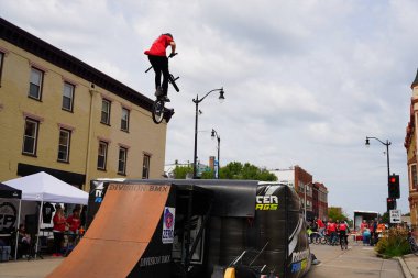 Racine, Wisconsin ABD - 16 Eylül 2023: BMX bisikletli dublörler, Racine, Wisconsin sokaklarında bir grup insan için yarı boru rampalarında dublörlük yapıyor.
