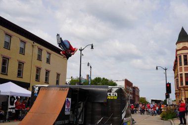 Racine, Wisconsin ABD - 16 Eylül 2023: BMX bisikletli dublörler, Racine, Wisconsin sokaklarında bir grup insan için yarı boru rampalarında dublörlük yapıyor.