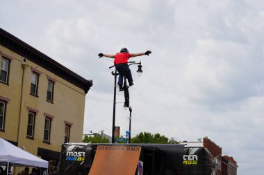 Racine, Wisconsin ABD - 16 Eylül 2023: BMX bisikletli dublörler, Racine, Wisconsin sokaklarında bir grup insan için yarı boru rampalarında dublörlük yapıyor.