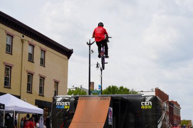 Racine, Wisconsin ABD - 16 Eylül 2023: BMX bisikletli dublörler, Racine, Wisconsin sokaklarında bir grup insan için yarı boru rampalarında dublörlük yapıyor.