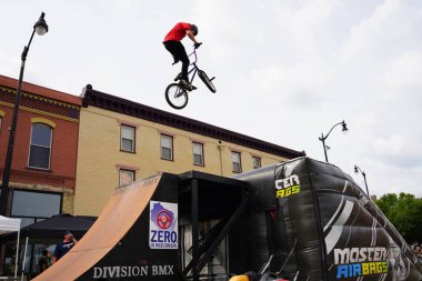 Racine, Wisconsin ABD - 16 Eylül 2023: BMX bisikletli dublörler, Racine, Wisconsin sokaklarında bir grup insan için yarı boru rampalarında dublörlük yapıyor.