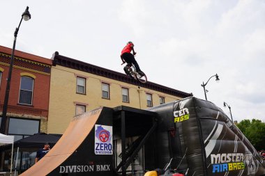 Racine, Wisconsin ABD - 16 Eylül 2023: BMX bisikletli dublörler, Racine, Wisconsin sokaklarında bir grup insan için yarı boru rampalarında dublörlük yapıyor.