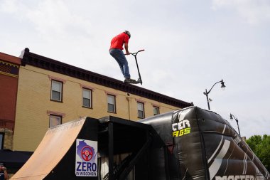 Racine, Wisconsin ABD - 16 Eylül 2023: BMX bisikletli dublörler, Racine, Wisconsin sokaklarında bir grup insan için yarı boru rampalarında dublörlük yapıyor.