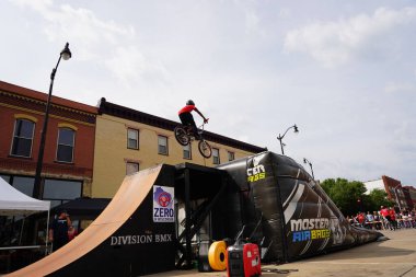 Racine, Wisconsin ABD - 16 Eylül 2023: BMX bisikletli dublörler, Racine, Wisconsin sokaklarında bir grup insan için yarı boru rampalarında dublörlük yapıyor.