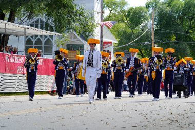 Warrens, Wisconsin USA - September 25th, 2022: Mauston High School Cheese Head marching band marched in Cranfest parade 2022. clipart