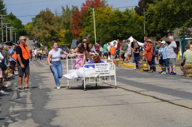 Green Lake, Wisconsin USA - September 23rd, 2023: Community members enjoyed a family event of bed racing on the streets of Green Lake. clipart