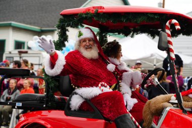 La Crosse, Wisconsin ABD - 1 Ekim 2022: Noel Baba kostümü giymiş bir adam Oktoberfest geçit töreninde seyircilere el sallıyor.