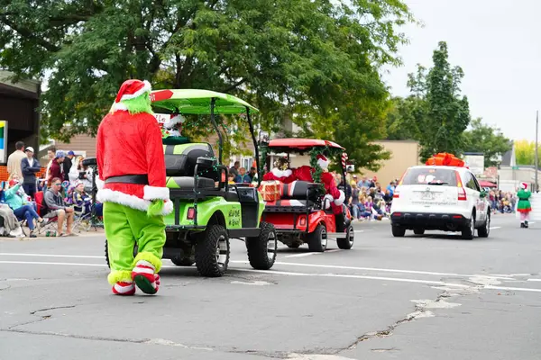 La Crosse, Wisconsin ABD - 1 Ekim 2022 Grinch Noel kostümü giyen ve Ekim Festivali 2022 geçit töreninde izleyicilerle etkileşime giren bir adam.