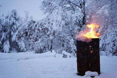 Soğuk kış boyunca yanan çöp kovası dışarıda durur..