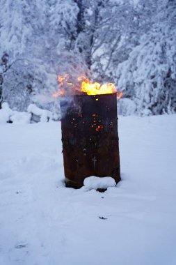 Soğuk kış boyunca yanan çöp kovası dışarıda durur..