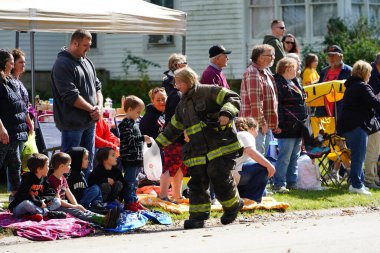 Warrens, Wisconsin USA - September 24th, 2022: Local fire fighters participated and handed out candy to spectators at Cranfest 2022 parade. clipart