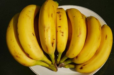 Bir grup olgun muz servis edilmeye hazır bir masada oturuyor..