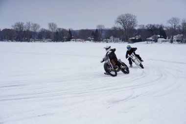 Hortonville, Wisconsin / ABD - 26 Ocak 2019: Toprak motosikletli sürücüler donmuş buzlu göl üzerinde gezinirken eğleniyorlardı