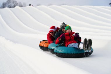 Kewaskum, Wisconsin / ABD - 24 Aralık 2019: Birçok aile ferdi Noel 'den bir gün önce Noel Slalom etkinliği için Sunburst Kış Spor Parkı' na kar borusu dökerek eğlenmeye geldi..  