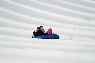 Kewaskum, Wisconsin / ABD - 24 Aralık 2019: Birçok aile ferdi Noel 'den bir gün önce Noel Slalom etkinliği için Sunburst Kış Spor Parkı' na kar borusu dökerek eğlenmeye geldi..  