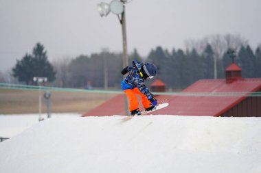 Kewaskum, Wisconsin / ABD - 24 Aralık 2019: Topluluk üyeleri Noel 'den bir gün önce Noel Slalom etkinliği için Sunburst Kış Spor Parkı' nda snowboard yaparken eğlenmek için dışarı çıktılar. 