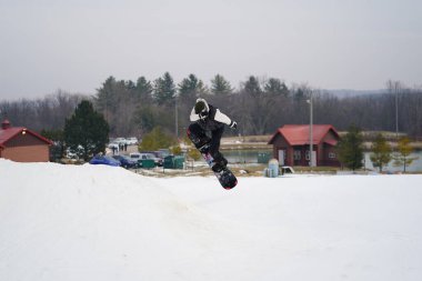 Kewaskum, Wisconsin / ABD - 24 Aralık 2019: Topluluk üyeleri Noel 'den bir gün önce Noel Slalom etkinliği için Sunburst Kış Spor Parkı' nda snowboard yaparken eğlenmek için dışarı çıktılar. 
