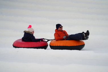 Kewaskum, Wisconsin / ABD - 24 Aralık 2019: Birçok aile ferdi Noel 'den bir gün önce Noel Slalom etkinliği için Sunburst Kış Spor Parkı' na kar borusu dökerek eğlenmeye geldi..  