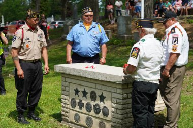 Oconomowoc, Wisconsin / ABD - 25 Mayıs 2020: Gaziler ve kıdemli subaylar, Anma Günü onuruna Güzeller Mezarlığı 'ndaki bilinmeyen asker mezarına şehit askerlerin kurdelelerini yerleştirdiler.