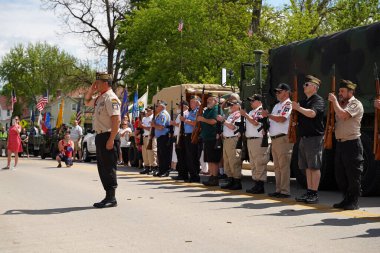 Oconomowoc, Wisconsin / ABD - 25 Mayıs 2020: Kıdemli ordu subayları ve gazileri, covid-19 'un sosyal uzaklık nedenine rağmen, şehit askerleri anma gününde onurlandırmak üzere sıraya girdiler.