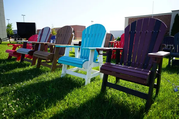 Colorful wooden lawn chairs set up outside to be sold in the fond du lac, wisconsin area.