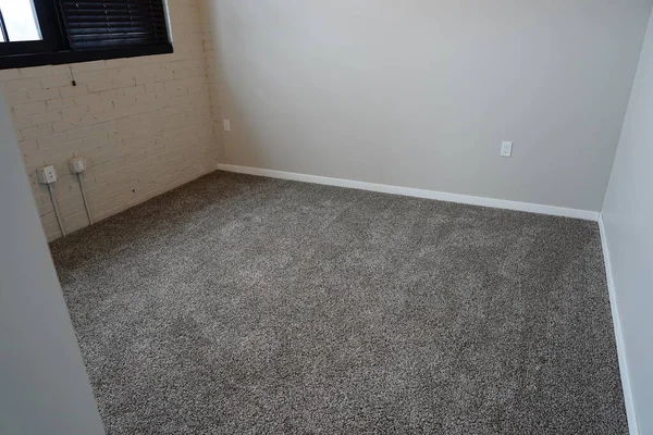 Grey carpeted bedroom inside an apartment unit.