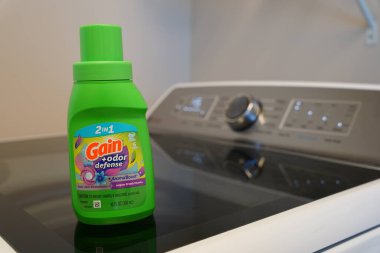 Fond du Lac, Wisconsin USA - 4 Mart 2024: Green 10 fl. Ons. Çamaşır odasındaki çamaşır makinesinin üstünde Gain marka deterjan var..
