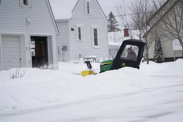 stock image Mauston, Wisconsin USA - January 19th, 2021: Man rides a John Deere tractor to blow snow off his driveway.