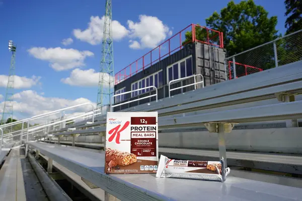 ビーバーダム ウィスコンシン 2020年6月27日 特別なKタンパク質ミールバー ダブルチョコレート6パック 59オンスバー5グラムの繊維と12ミネラルとビタミンがサッカー場のベンチに座る ロイヤリティフリーのストック画像