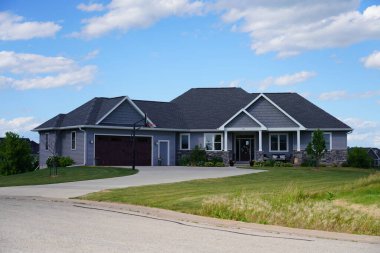 New Lisbon, Wisconsin ABD - 20 Mayıs 2022: Tan ve Green 2 araç garajı Tek katlı çiftlik evi kırsal kesimde duruyor