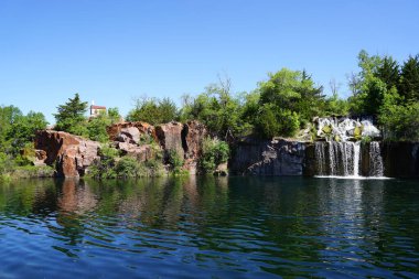 Rock formation, waterfalls, and pond at Daggett Memorial Park in Montello, Wisconsin clipart