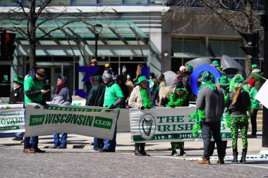 Milwaukee, Wisconsin ABD - 12 Mart 2022: Shamrock kulübü üyeleri Aziz Patrick günü için giyindiler ve geçit töreni için pankart taşıdılar.
